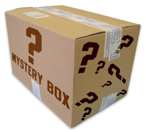 Image of a rectangle cardboard box covered in printed question marks. The words "Mystery Box" are written on the side. 